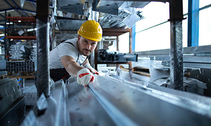 industrial worker handling metal material in warehouse 426x254