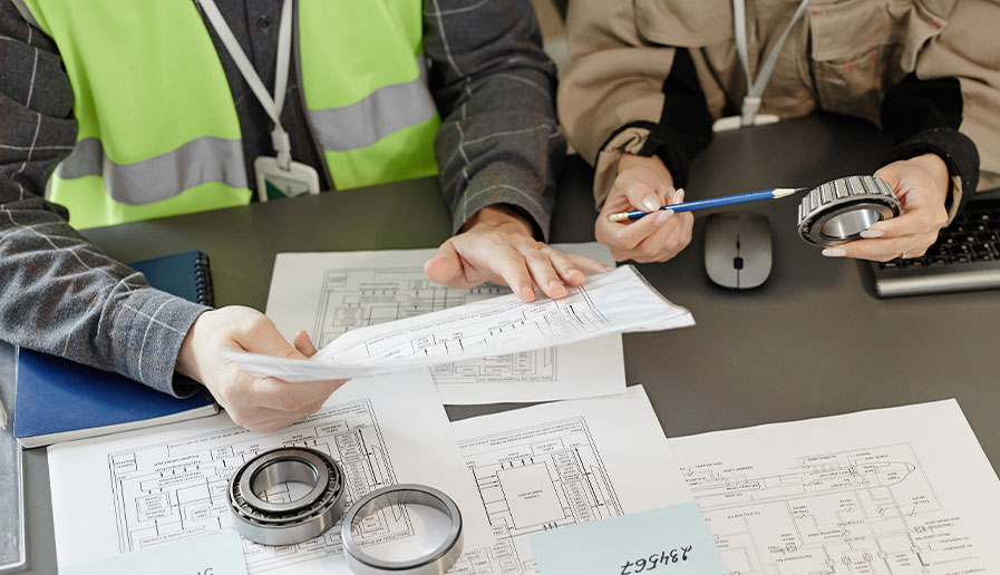 Two workers looking at schematics